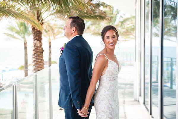 bride and groom standing back to back before their first look at the Opal Sands Resort