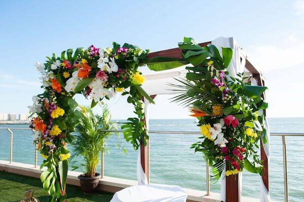 A Chuppah with bright tropical colors overlooking the Gulf of Mexico at the Opal Sands Resort