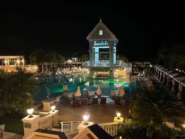 night time view of pool and lit up Sandals sign