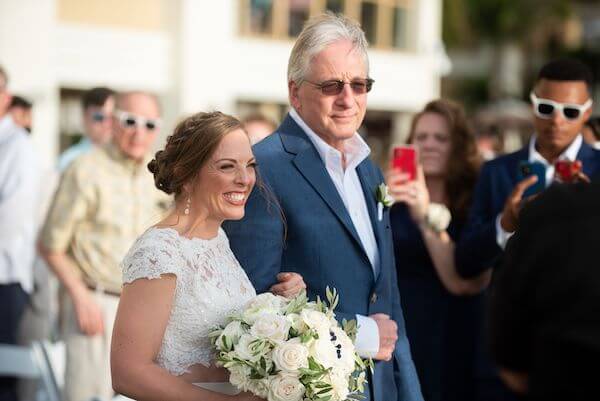 bride with a huge grin as she walks down the aisle