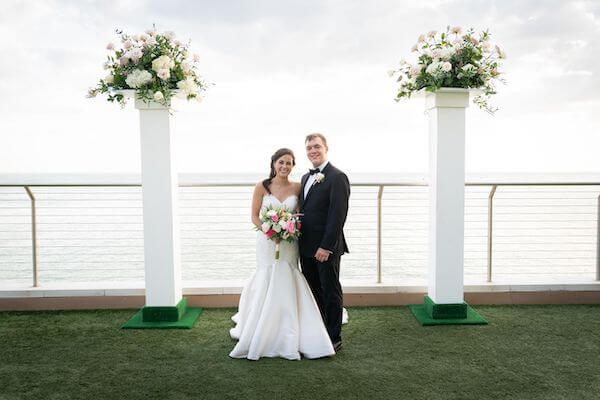 bride and groom posing for photos after their Clearwater Beach wedding ceremony