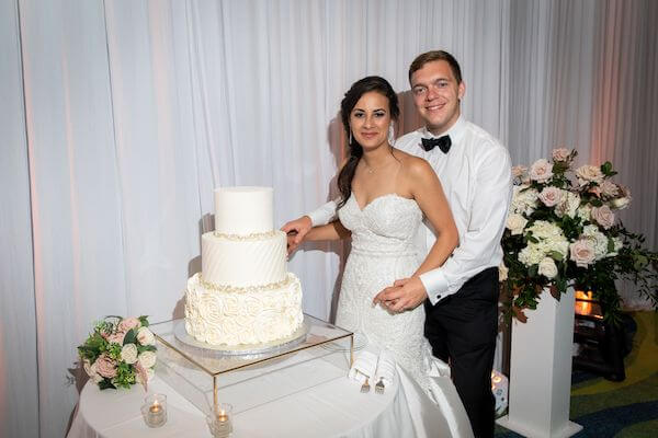 bride and groom cutting their wedding cake at their Opal Sands Resort wedding reception