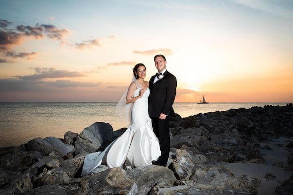 Sailboat and Sunset behind newlywed couple on Clearwater Beach