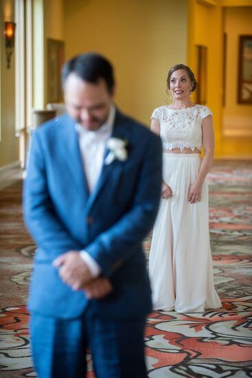 bride walking up behind her groom during their first look