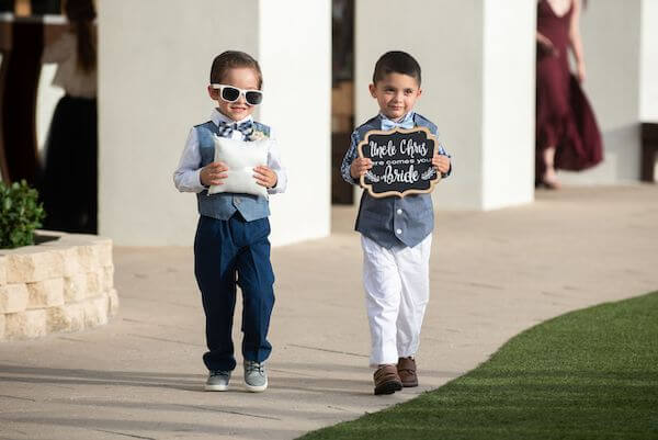 ring bear and another little guy carrying a here comes the bride sign at a Clearwater Beach wedding ceremony