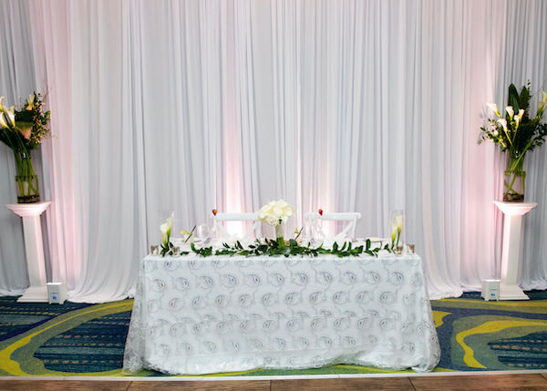 sweetheart table with silver overlay and white calla lilies at the Opal Sands