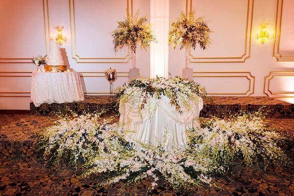 sweetheart table with orchids repurposed from the ceremony structure