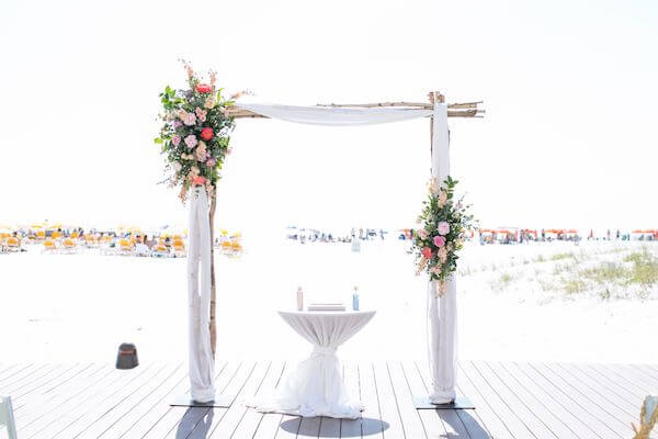 wedding arch on Clearwater beach decorated with pink flowers and fabric