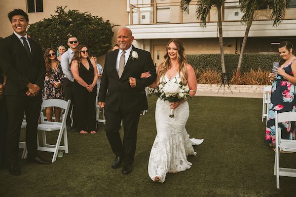 Bride walking down the aisle at her Sandpearl Resort wedding ceremony