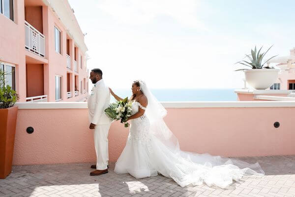 bride walking up behind her groom to be during their first look on the roof top of the Hyatt Regency Clearwater Beach