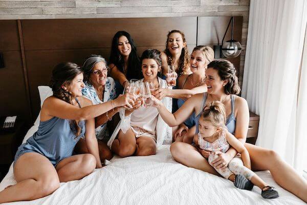 bride toasting with her wedding party while they get ready for the wedding