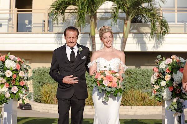 Bride and her father walking down the aisle at her wedding ceremony