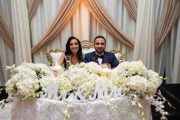 Tampa bride and groom sitting at their elegant sweetheart table