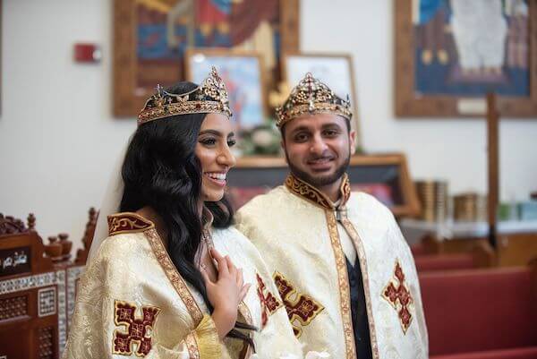 Brdie and groom wearing robes and crowns during their Tampa Bay Coptic Orthodox wedding ceremony