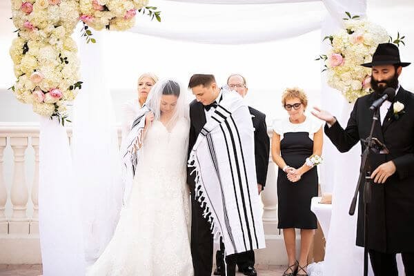 Bride and groom under a chuppah during their Clearwater beach Jewish wedding