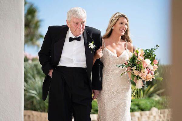 bride walking down the aisle escorted by her father