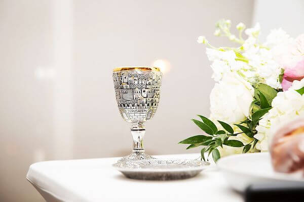 Kiddush cup and challah at a Jewish wedding reception