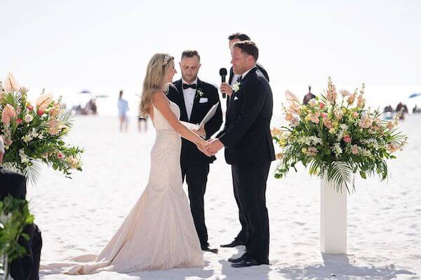 bride and groom exchanging wedding vows during their beach wedding at the Sandpearl Resort