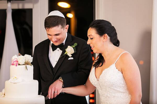 Jewish bride and groom cutting thier wedding cake