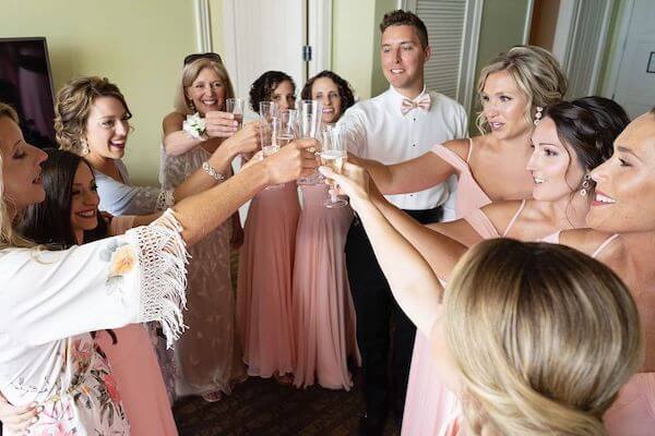 Bride and her wedding party cheersing in her suite at the Sandpearl Resort