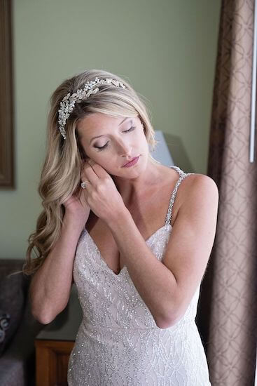 Beautiful bride putting on her earrings