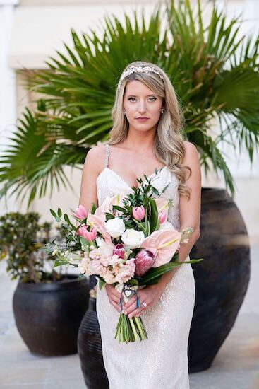 bride wearing a shimmering wedding gown carrying a pink and white bridal bouquet