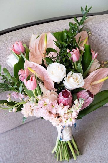 Pink and white bridal bouquet with anthurium, tulips, and Queen protea