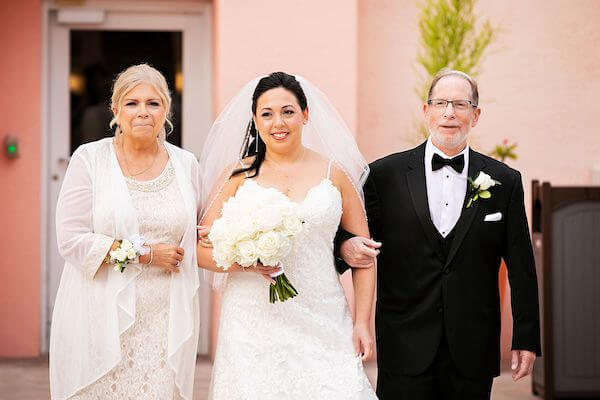 bride being escorted down the aisle by her parents during a Jewish wedding ceremony