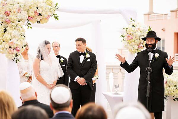 Bride and groom under a chuppah during their Clearwater beach Jewish wedding