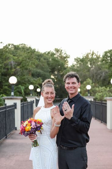 Bride and groom showing off their wedding rings after their garden wedding