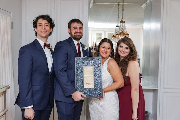 Tampa bride and groom holding thier ketubah with their witnesses