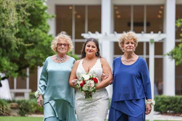 Bride walking down the aisle with her two moms!