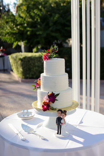 There tiered white wedding cake with custom bride and groom cake topper