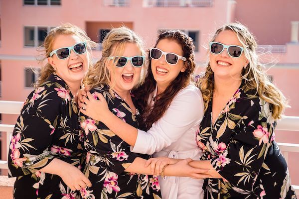 brid ena dwedding party in custom robes with fun sunglasses