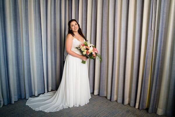 bride holding a bright tropical bouquet