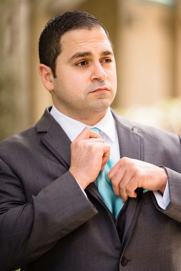 clearwater beach groom fixing his ocean colored tie