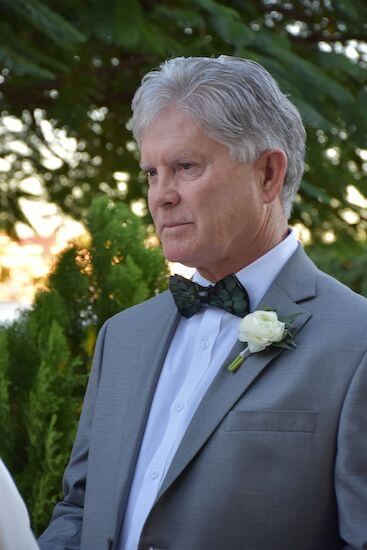 handsome groom in a grey suit with bow tie