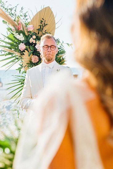 emotional groom watching his bride walk down the aisle