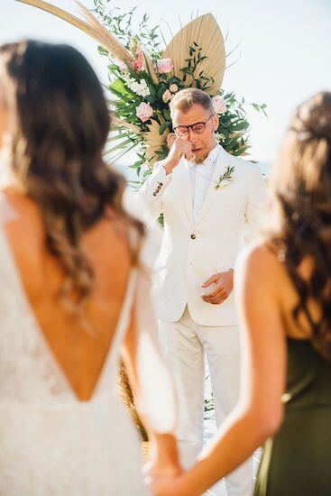 emotional groom watching his bride walk down the aisle