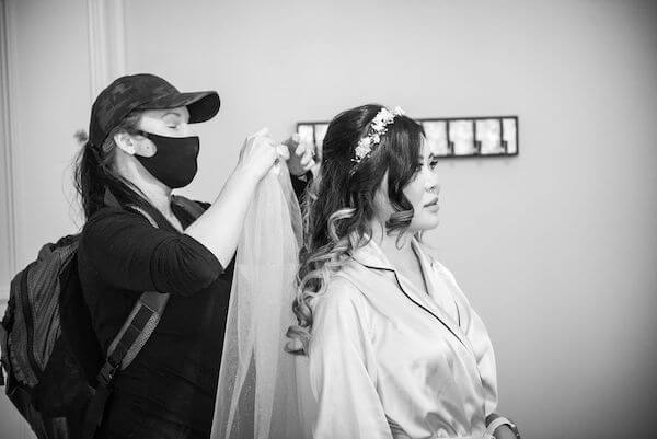 Hair stylist fixing a brides veil