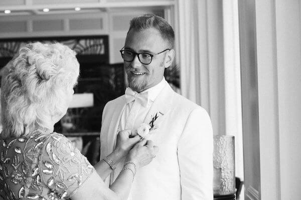 groom's mother pinning on his boutonniere