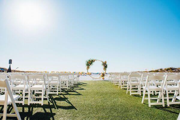 beach wedding with a gold toned moon gate and boho inspired floral