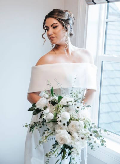 bride with bouquet in front of a window at the Belleview Inn