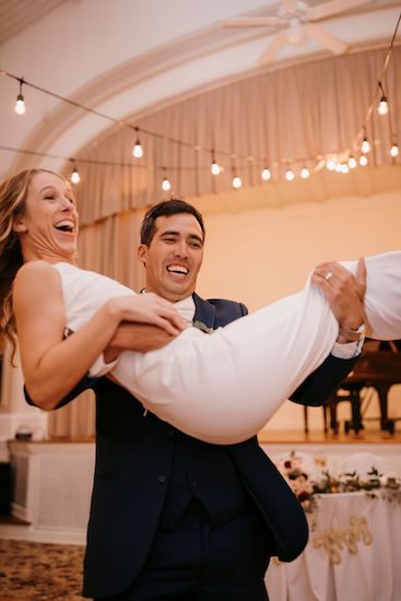 Groom sweeping his bride off her feet during their wedding introductions