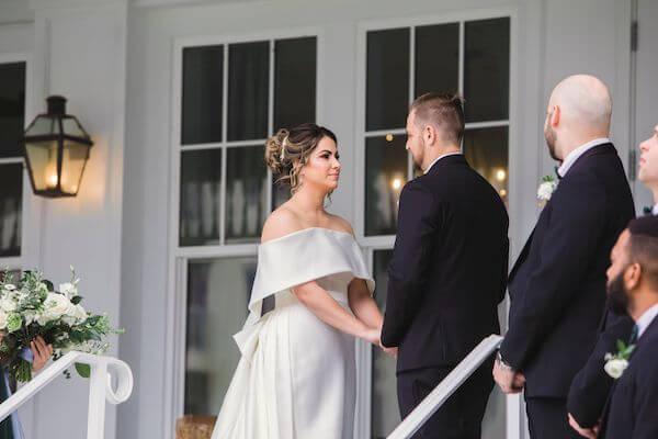 bride and groom exchanging vows on the porch of the Belleview Inn