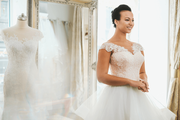 a bride with wedding insurance shopping for a gown