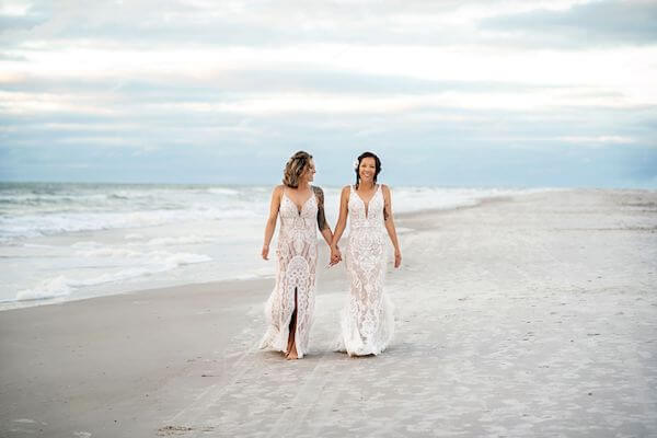 Two brides walking along the Gulf of Mexico