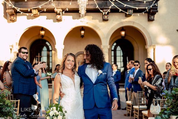 Couple recessing after thier outdoor wedding ceremony