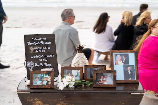 Antique table with memorial photos at a beach wedding