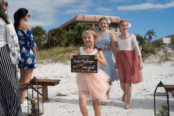 wedding party carrying a custom "Here Comes the Bride" sign